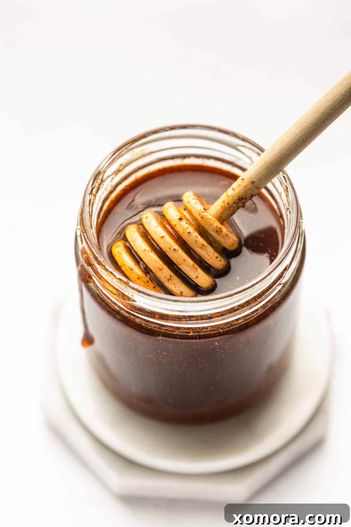 Sweet Heat Honey Drizzle 6 A charcuterie board featuring cheese, crackers, and a small bowl of hot honey for dipping.