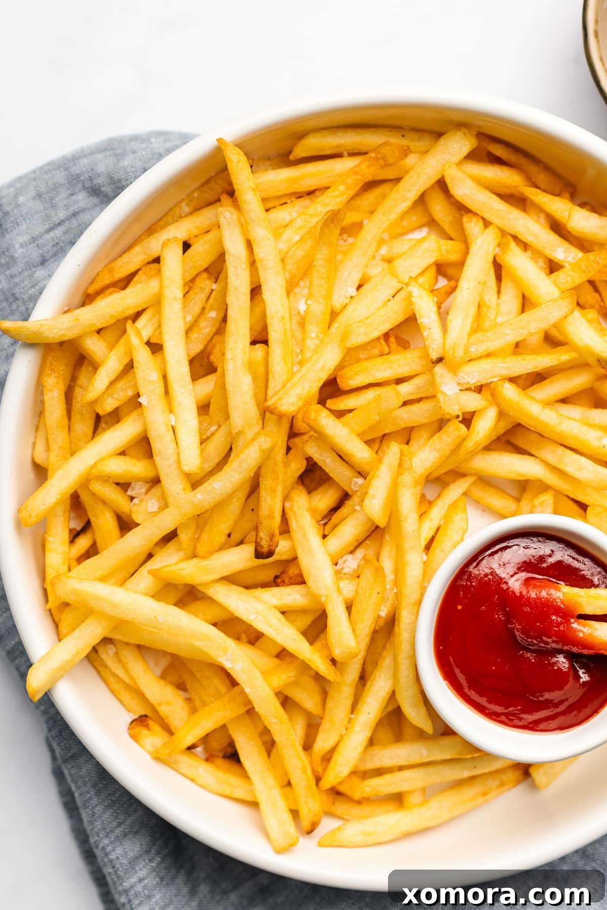 Perfectly Crispy Air Fryer Frozen Fries 4 Air Fryer Frozen French Fries being removed from air fryer