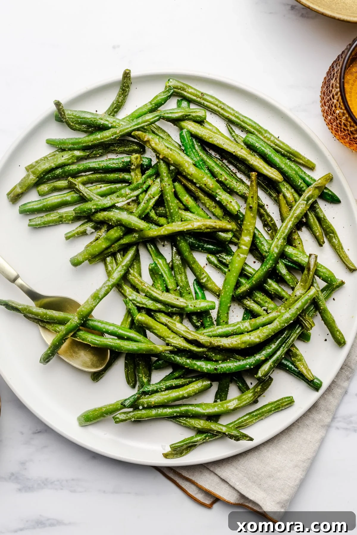 Crispy Air Fryer Frozen Green Beans 2 Air Fryer Frozen Green Beans in an air fryer basket, perfectly cooked and lightly browned.
