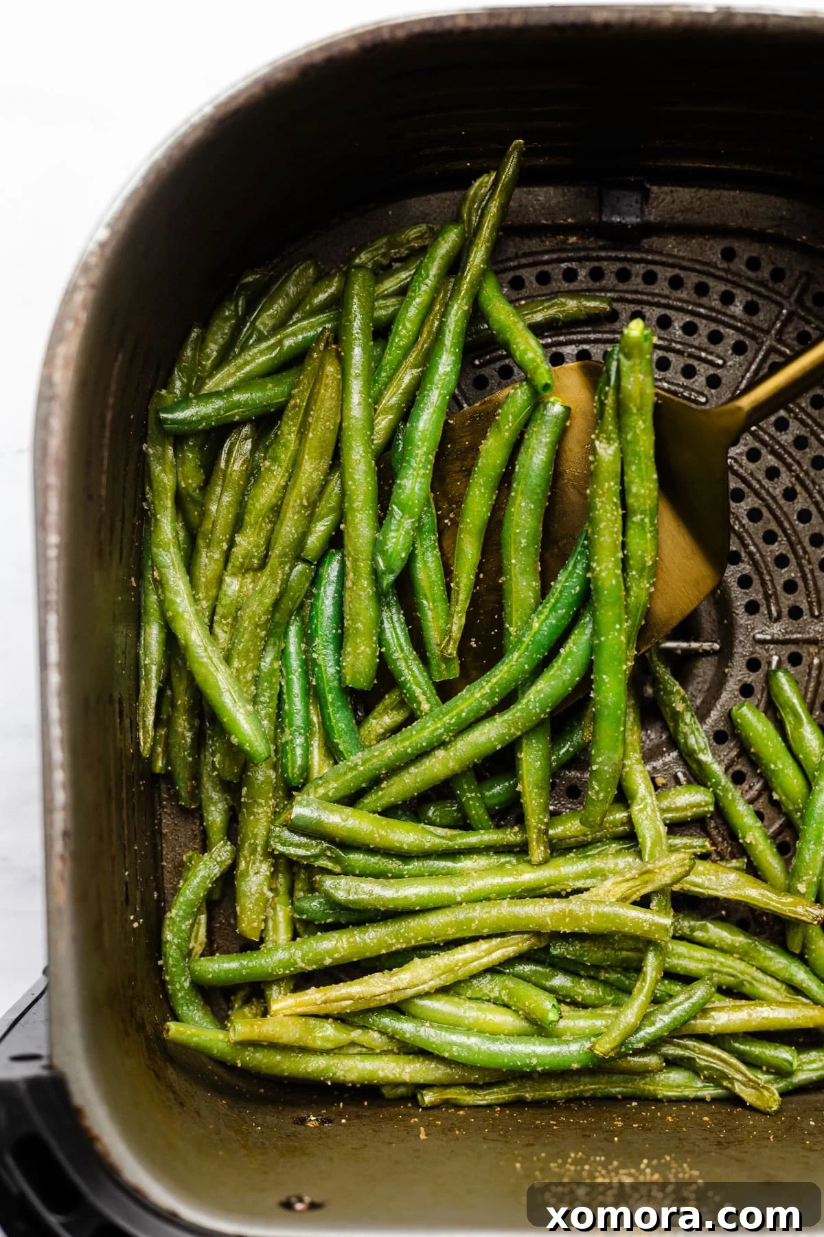 Crispy Air Fryer Frozen Green Beans 5 Air fried green beans in an air fryer basket, ready to be served.