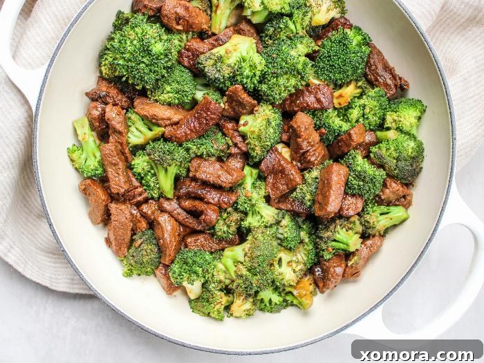 Tender Beef Crisp Broccoli 3 A perfectly cooked plate of soy-free beef and broccoli, garnished with fresh green onions and sesame seeds, showcasing its vibrant colors and delicious texture.