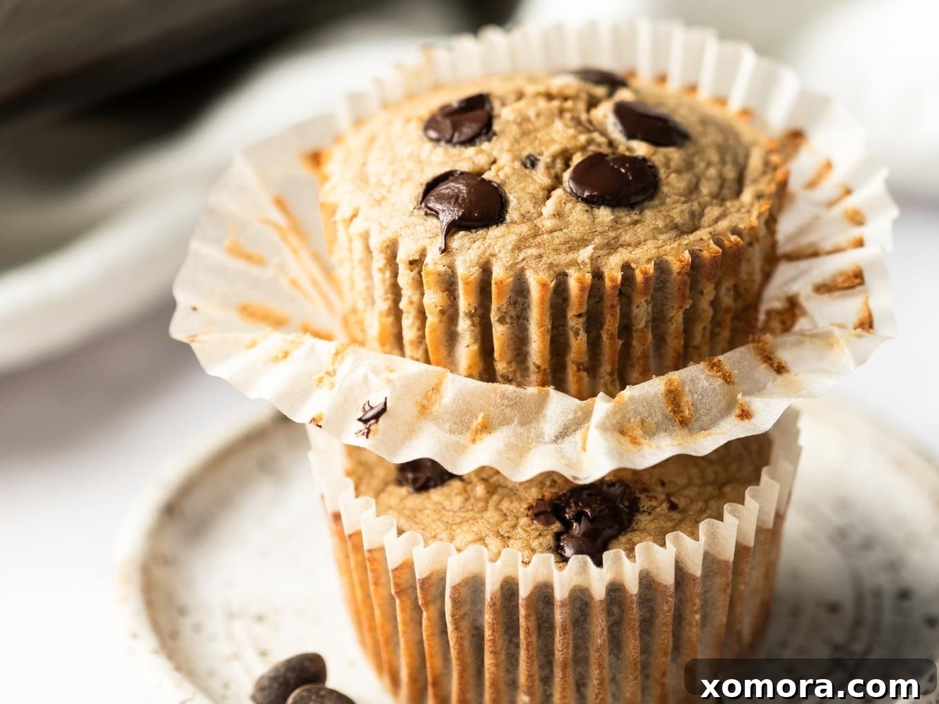 Golden Banana Oat Chocolate Chip Delights 5 A close-up of a chocolate chip banana oat muffin torn open, revealing its moist, tender interior and abundant chocolate chips.
