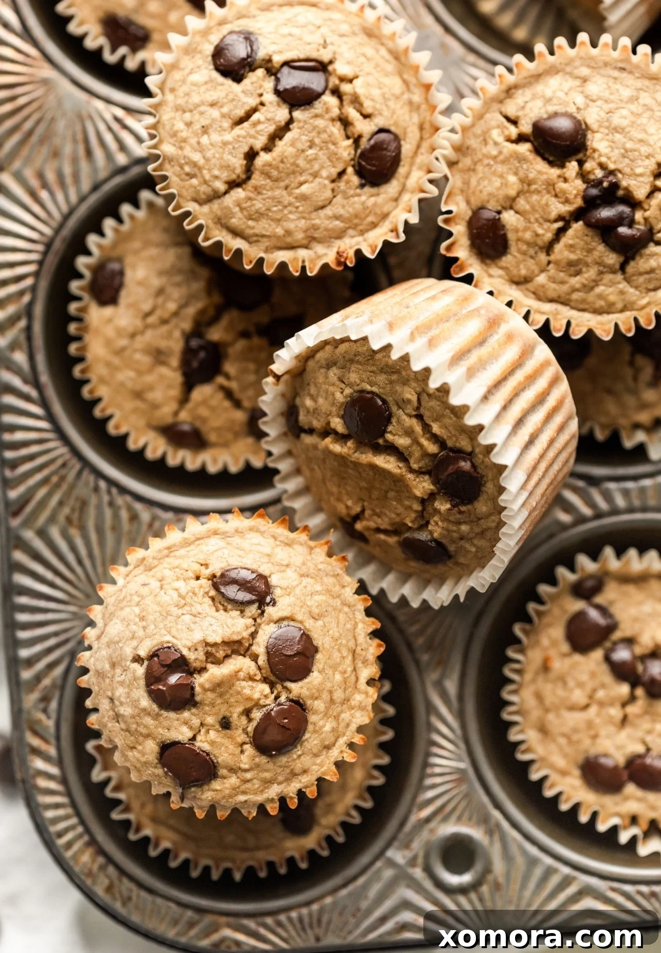 Golden Banana Oat Chocolate Chip Delights 6 Three perfectly baked chocolate chip banana oat muffins on a wire cooling rack, ready to be enjoyed.