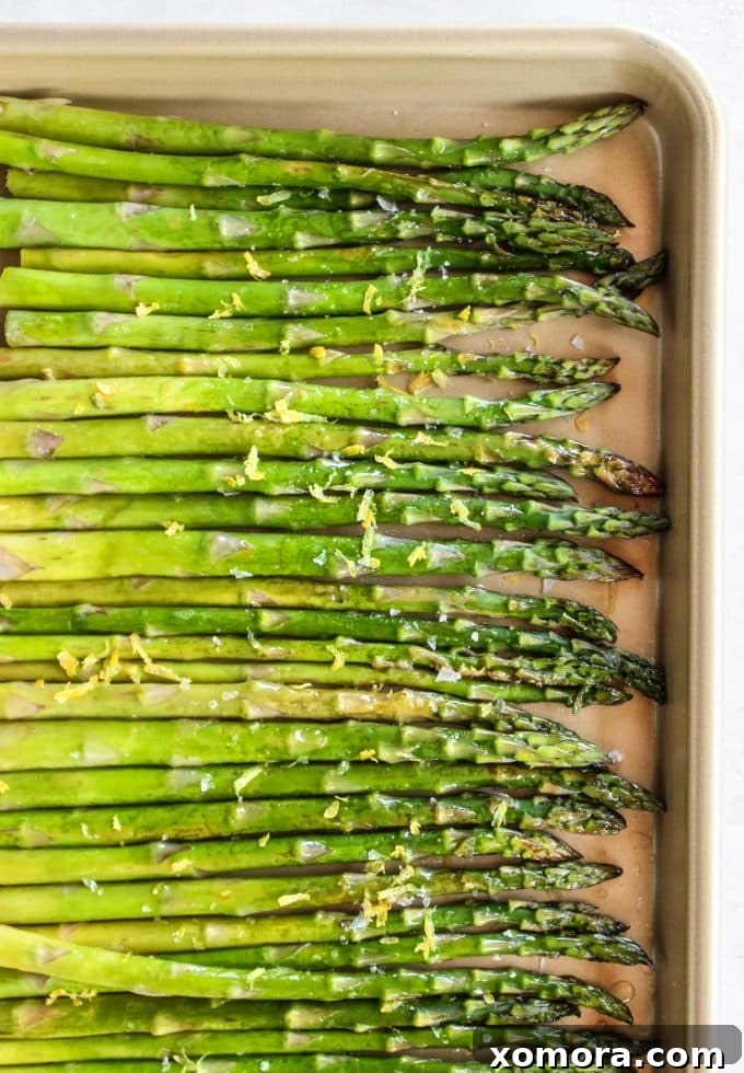 Zesty Roasted Asparagus 4 A serving of roasted asparagus with lemon on a ceramic plate, ready to be enjoyed.