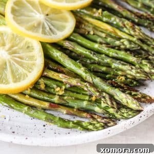 Zesty Roasted Asparagus 5 Close-up of roasted asparagus spears with lemon wedges.