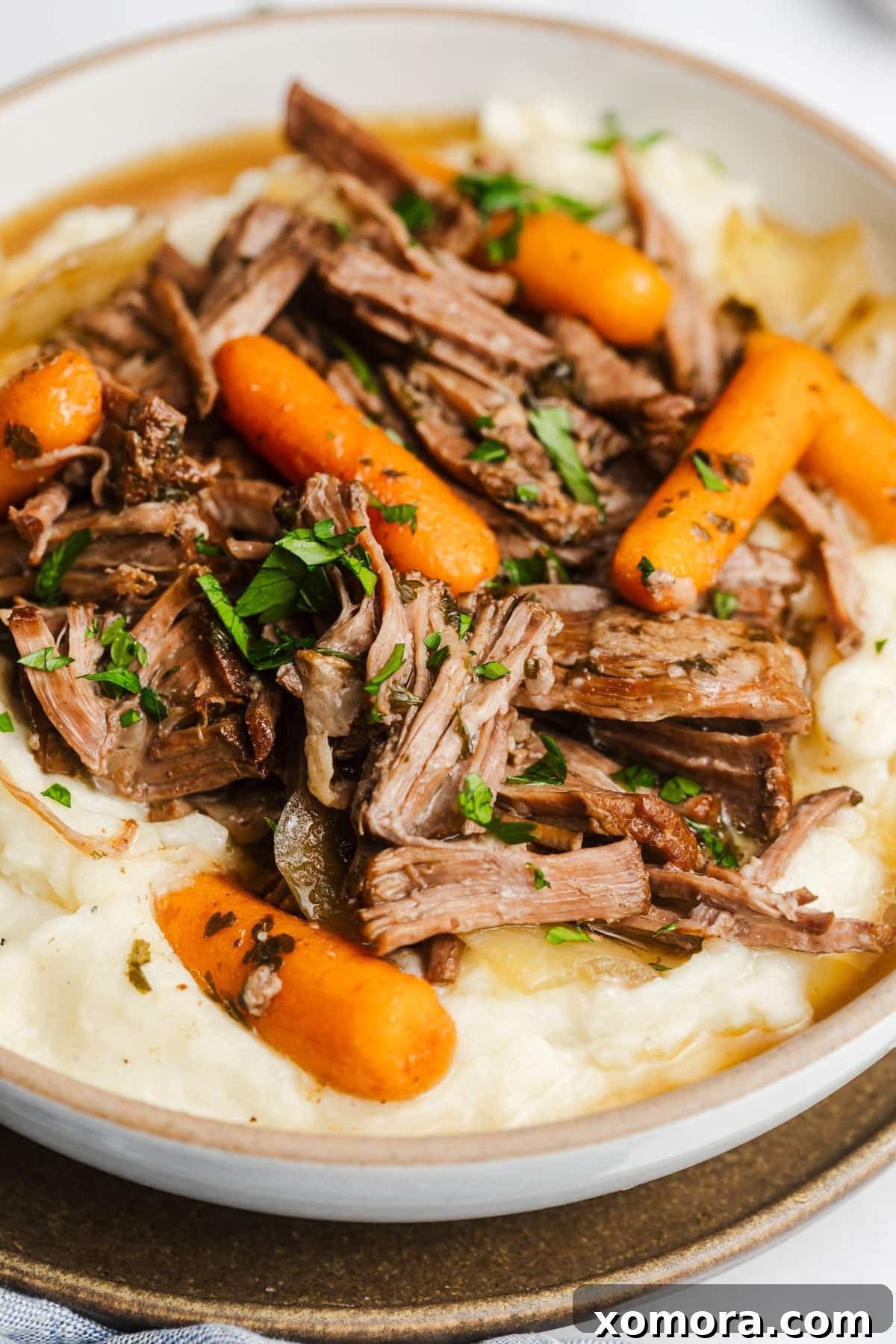 Effortless Slow Cooker Garlic Herb Pot Roast 2 A perfectly cooked slow cooker garlic herb pot roast, served with carrots and onions.