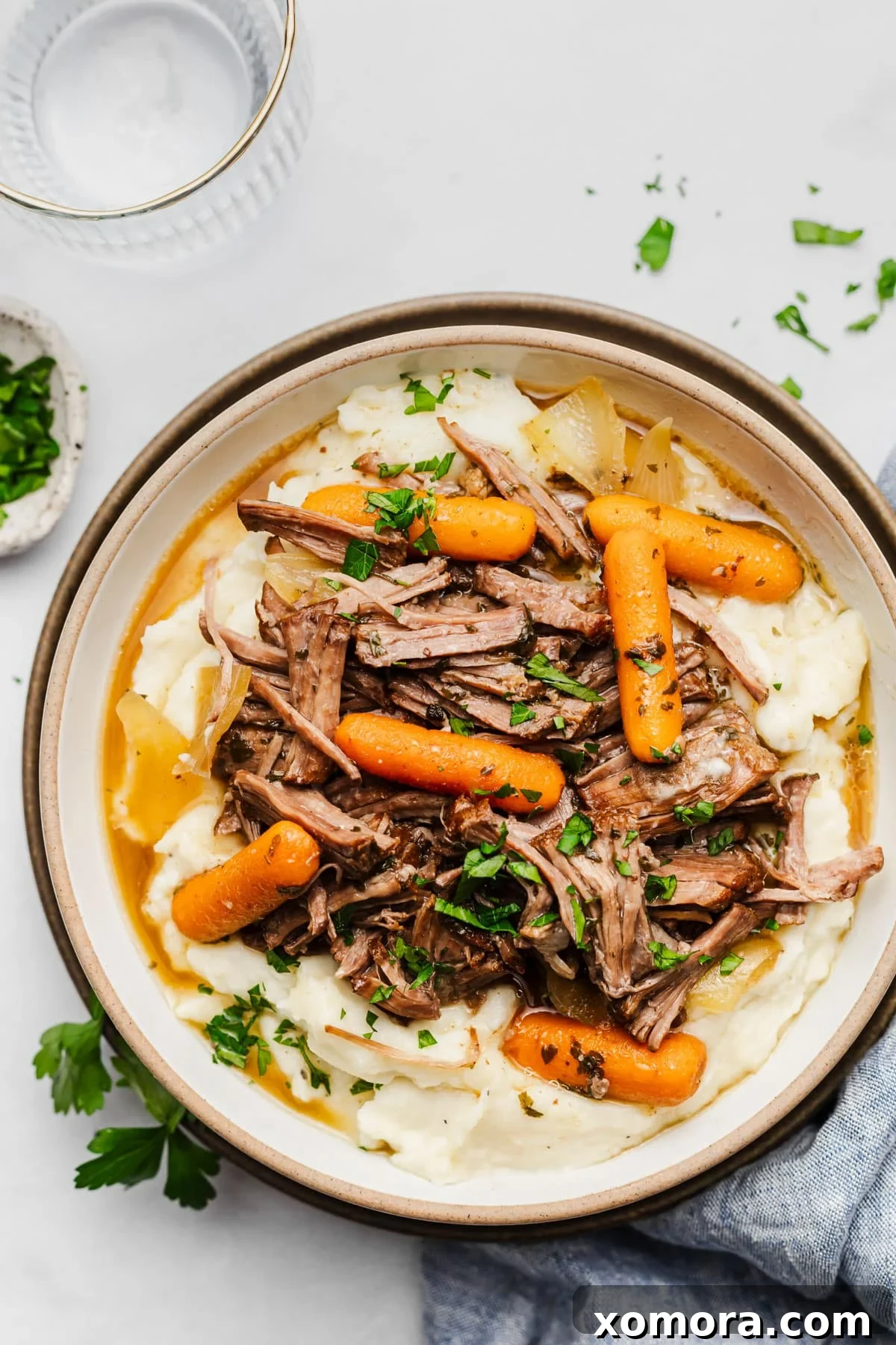 Effortless Slow Cooker Garlic Herb Pot Roast 5 Shredded pot roast with gravy in a slow cooker, ready to be served.