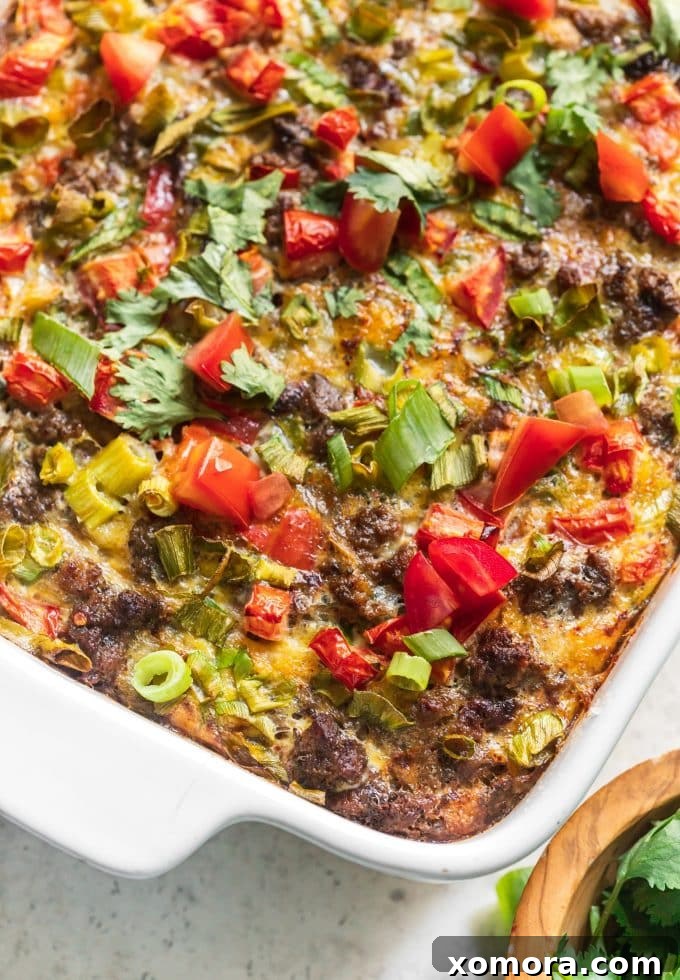 Zesty Plant-Based Mexican Breakfast Bake 2 A large slice of Dairy-Free Mexican Breakfast Casserole with layers of beef, potatoes, and eggs, topped with fresh cilantro and salsa.