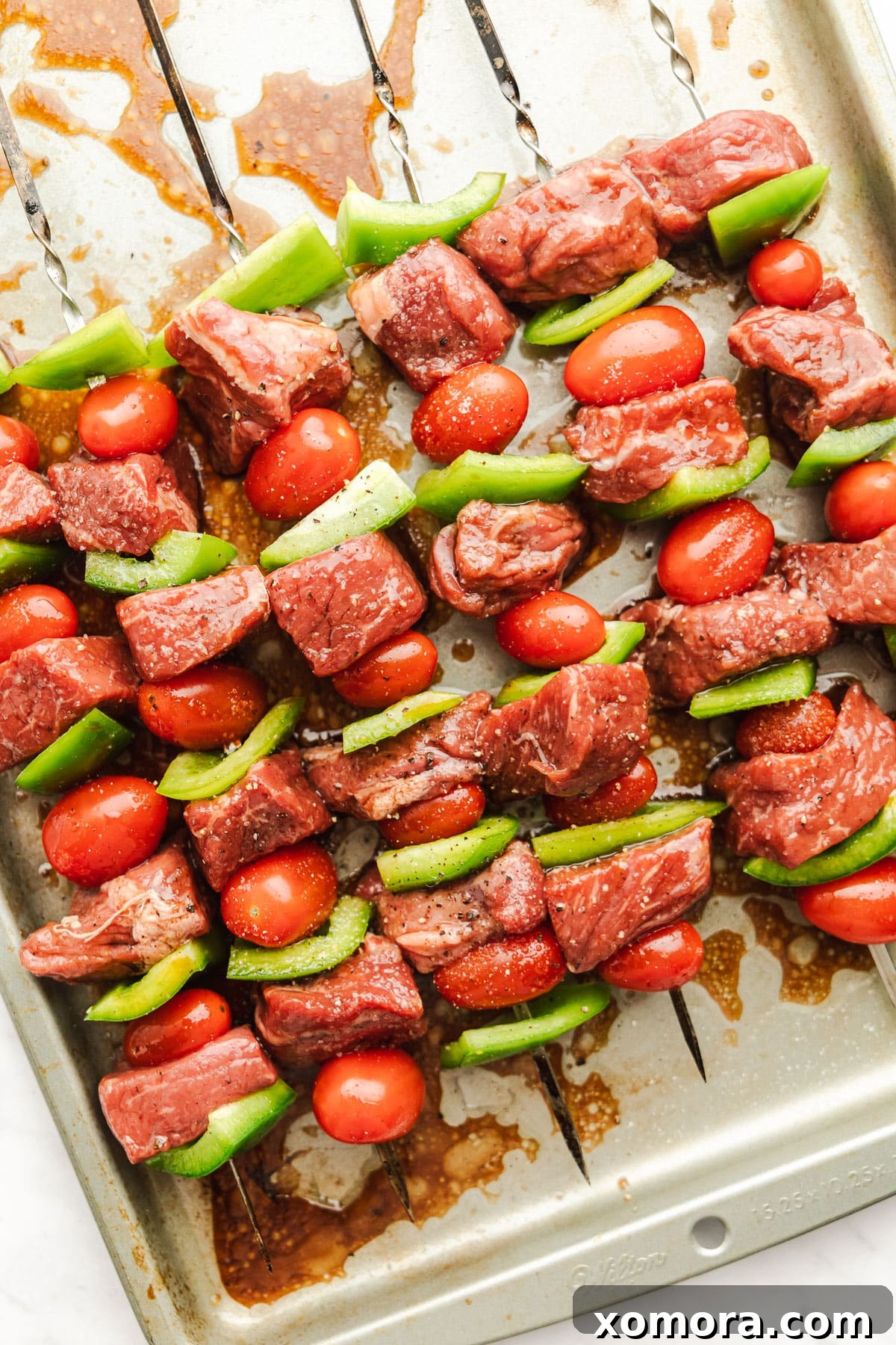 Zesty Pesto Steak Skewers with Charred Garden Vegetables 3 Close-up of grilled pesto steak kabobs on a platter.