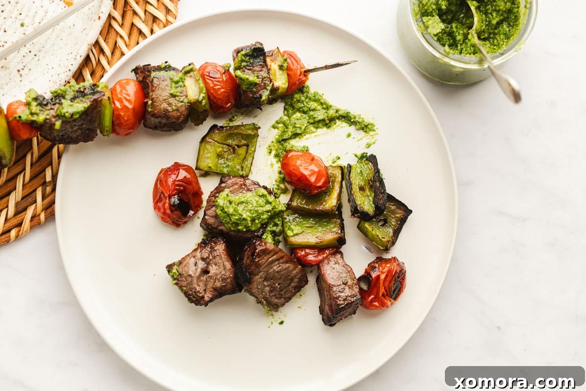 Zesty Pesto Steak Skewers with Charred Garden Vegetables 4 Cooked pesto steak kabobs drizzled with pesto.
