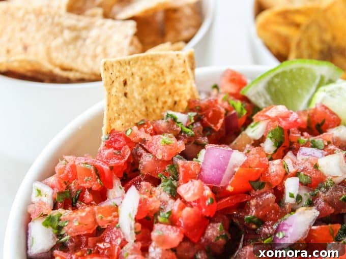 A close-up of fresh Pico de Gallo in a rustic bowl, highlighting the texture of the diced vegetables.