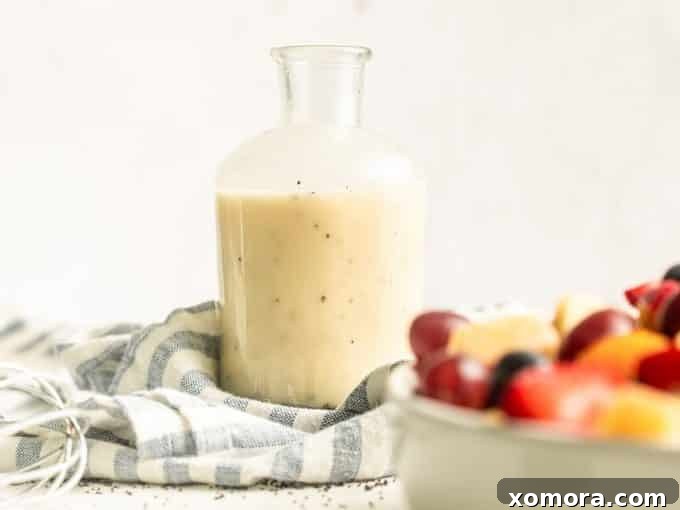 Zesty Lemon Poppy Seed Dressing 4 A bowl of fresh fruit salad with berries, melon, and grapes, drizzled with lemon poppy seed dressing.