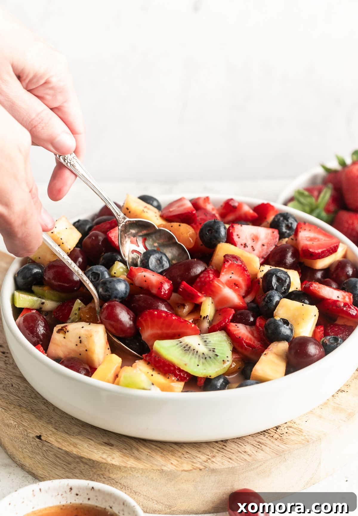 Vibrant Fruit Medley with Lemon Poppy Seed Drizzle 2 A beautifully arranged fruit salad with a variety of colorful fruits like strawberries, kiwi, grapes, blueberries, and pineapple, glistening with a creamy lemon poppy seed dressing.