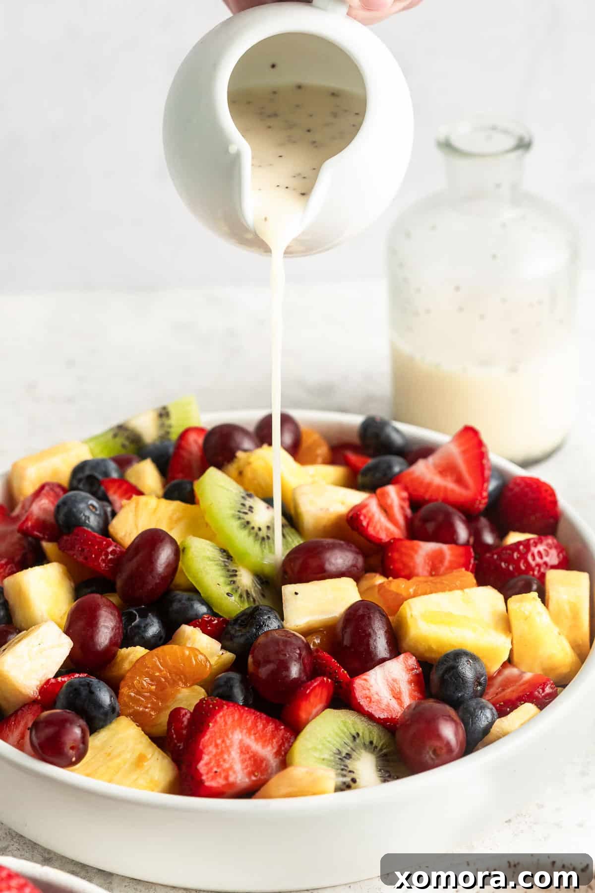 Vibrant Fruit Medley with Lemon Poppy Seed Drizzle 3 Close-up shot of the vibrant fruit salad, showing sliced kiwi, blueberries, and grapes, with a hint of the creamy lemon poppy seed dressing visible.