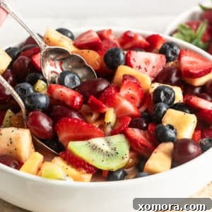 A finished fruit salad with lemon poppy seed dressing, presented in a bowl, ready to serve.
