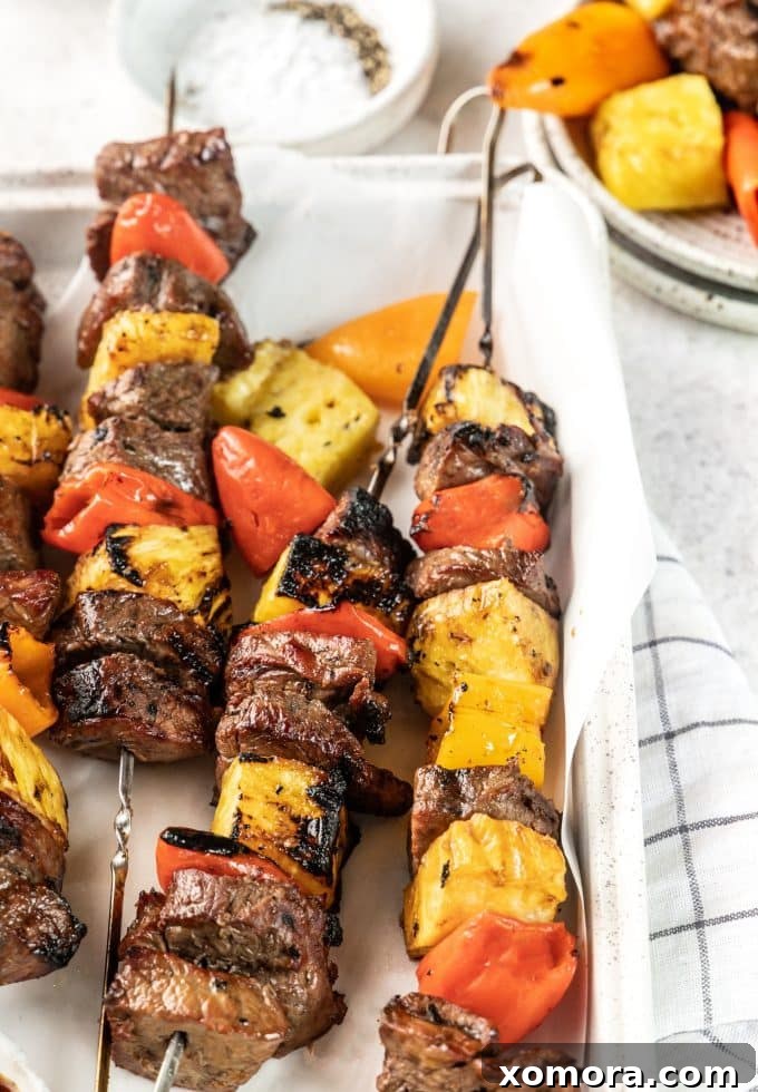 Aloha Grilled Steak Kabobs 2 Close-up of vibrant Hawaiian Steak Kabobs with grilled steak, pineapple, and sweet mini peppers, ready to be served.