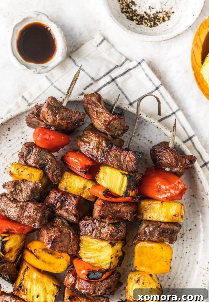 Aloha Grilled Steak Kabobs 5 Grilled Hawaiian Steak Kabobs with beautifully charred steak, pineapple, and peppers on skewers.