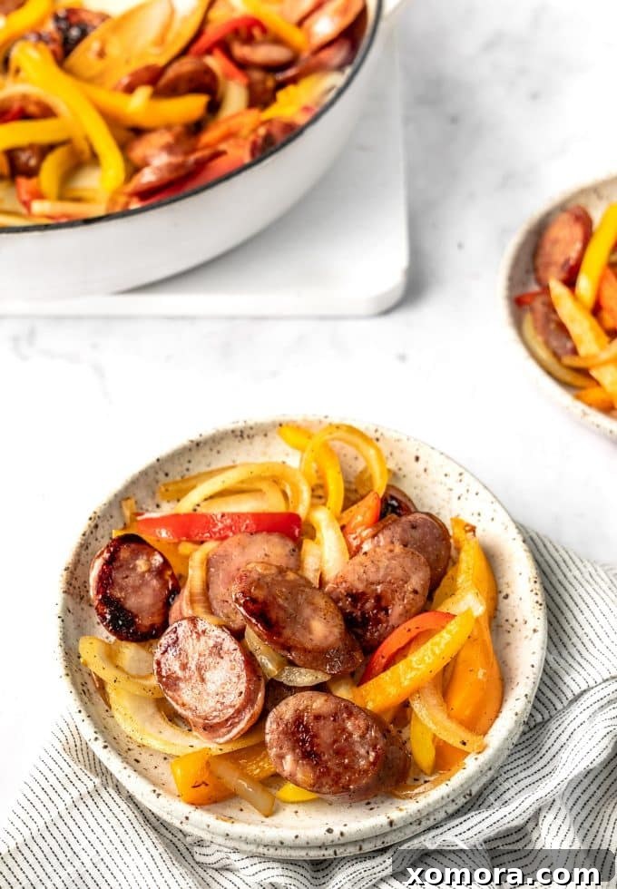 Close-up of the partially cooked sausage and fresh bell peppers in a skillet, showcasing the key ingredients.