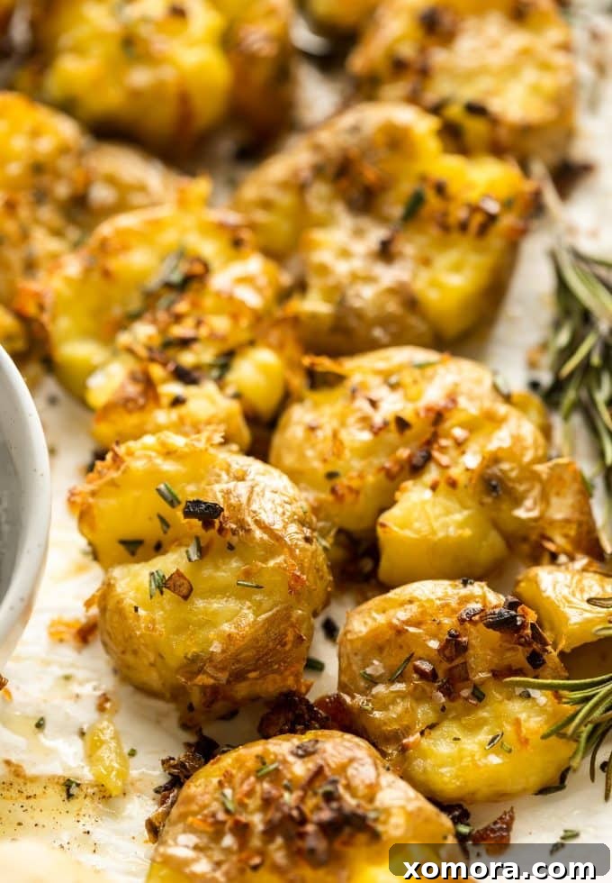 Crispy Rosemary Garlic Smashed Potatoes 2 Golden-brown crispy rosemary garlic smashed potatoes on a baking sheet, ready to serve.