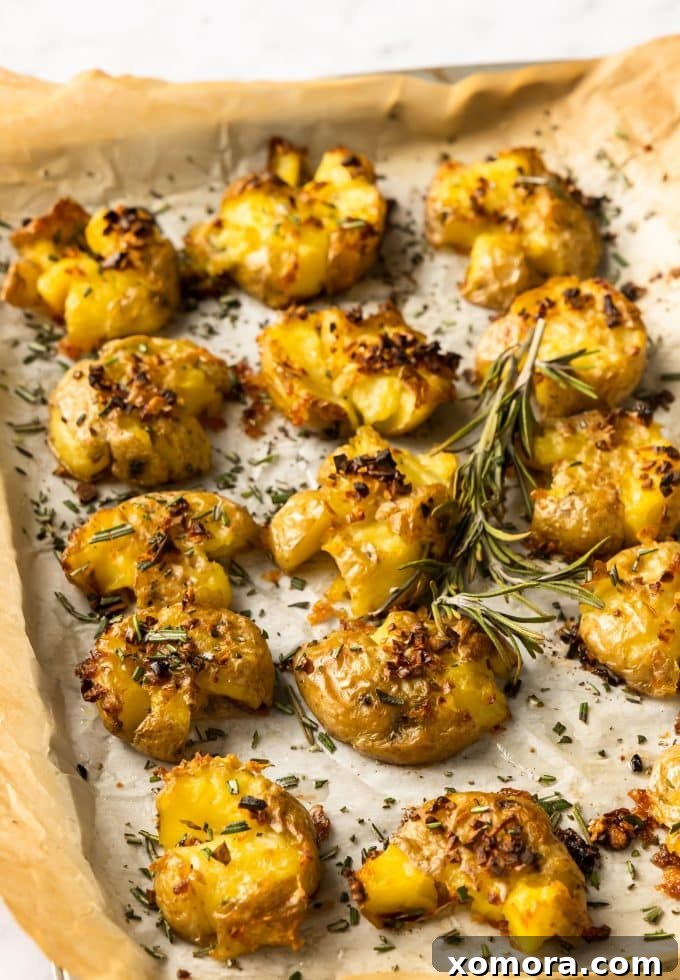 Crispy Rosemary Garlic Smashed Potatoes 5 Close-up of crispy smashed potatoes, garnished with fresh rosemary and sea salt.