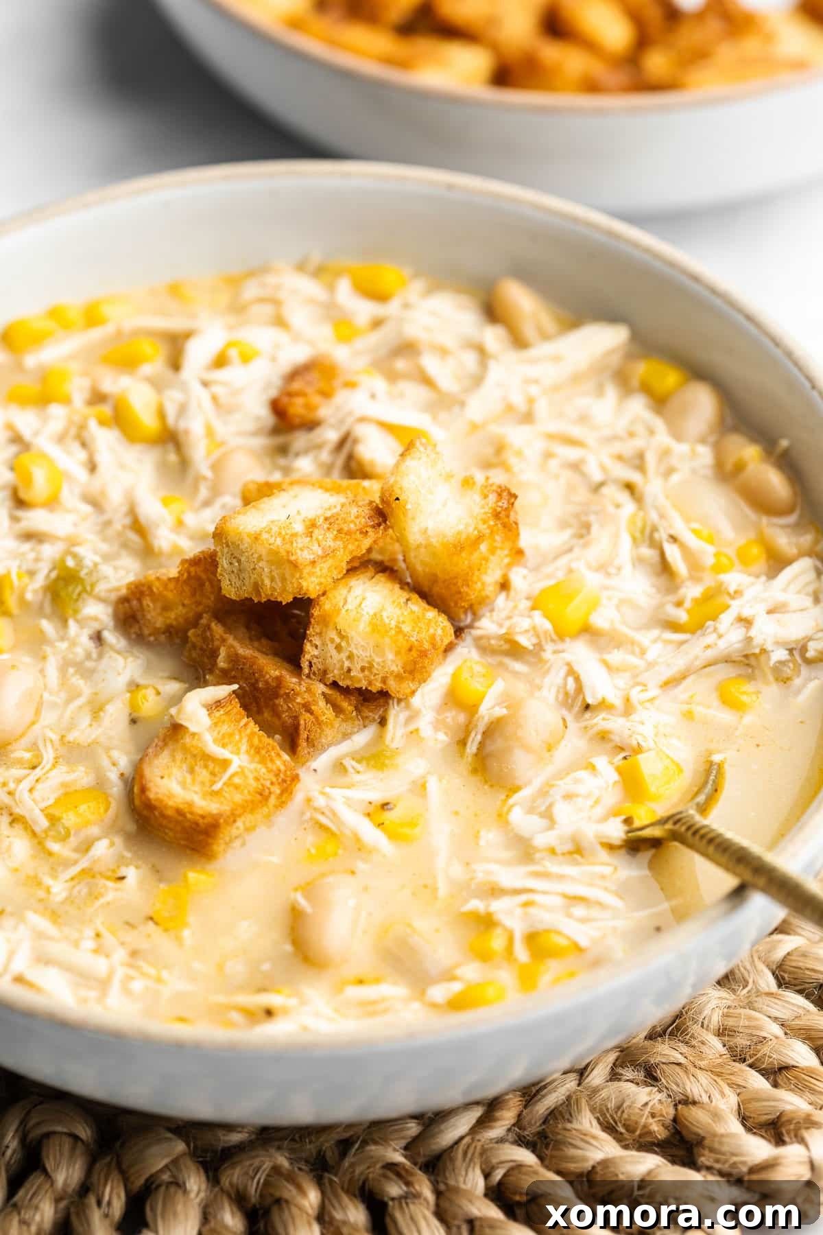 A large bowl of creamy Slow Cooker White Chicken Chili topped with fresh cilantro, ready to be served.