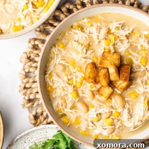A bowl of Slow Cooker White Chicken Chili with toppings.