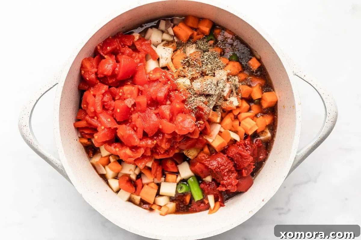 A close-up of ingredients for healthy 30-minute hamburger soup, including fresh vegetables, spices, and ground meat.