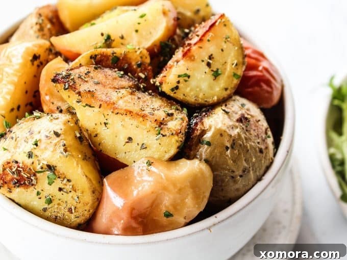 A close-up of roasted apples and potatoes, golden brown and seasoned.