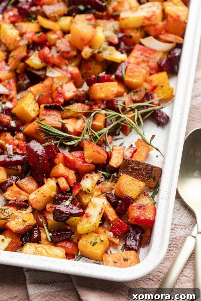 Herb-Kissed Roasted Root Medley 2 A vibrant platter of roasted root vegetables, including golden potatoes, sweet potatoes, beets, butternut squash, and carrots, garnished with fresh rosemary.