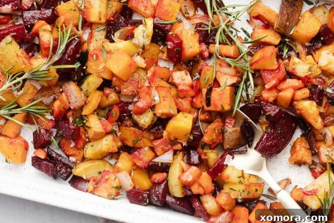 Herb-Kissed Roasted Root Medley 3 Close-up of diced root vegetables, including sweet potatoes, golden potatoes, and beets, ready for roasting on a baking sheet.