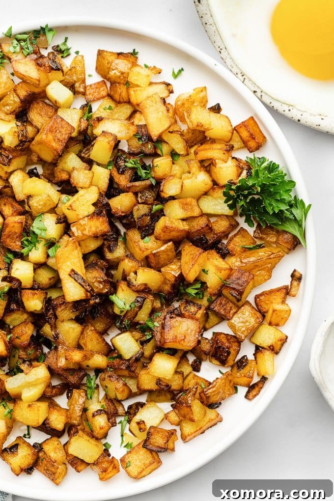 Diner-Style Breakfast Spuds 2 Crispy golden skillet breakfast potatoes in a cast iron pan, ready to be served