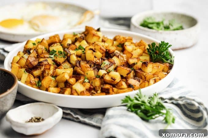 Diner-Style Breakfast Spuds 3 Close-up of golden brown diced potatoes and onions in a skillet, showcasing crispy texture
