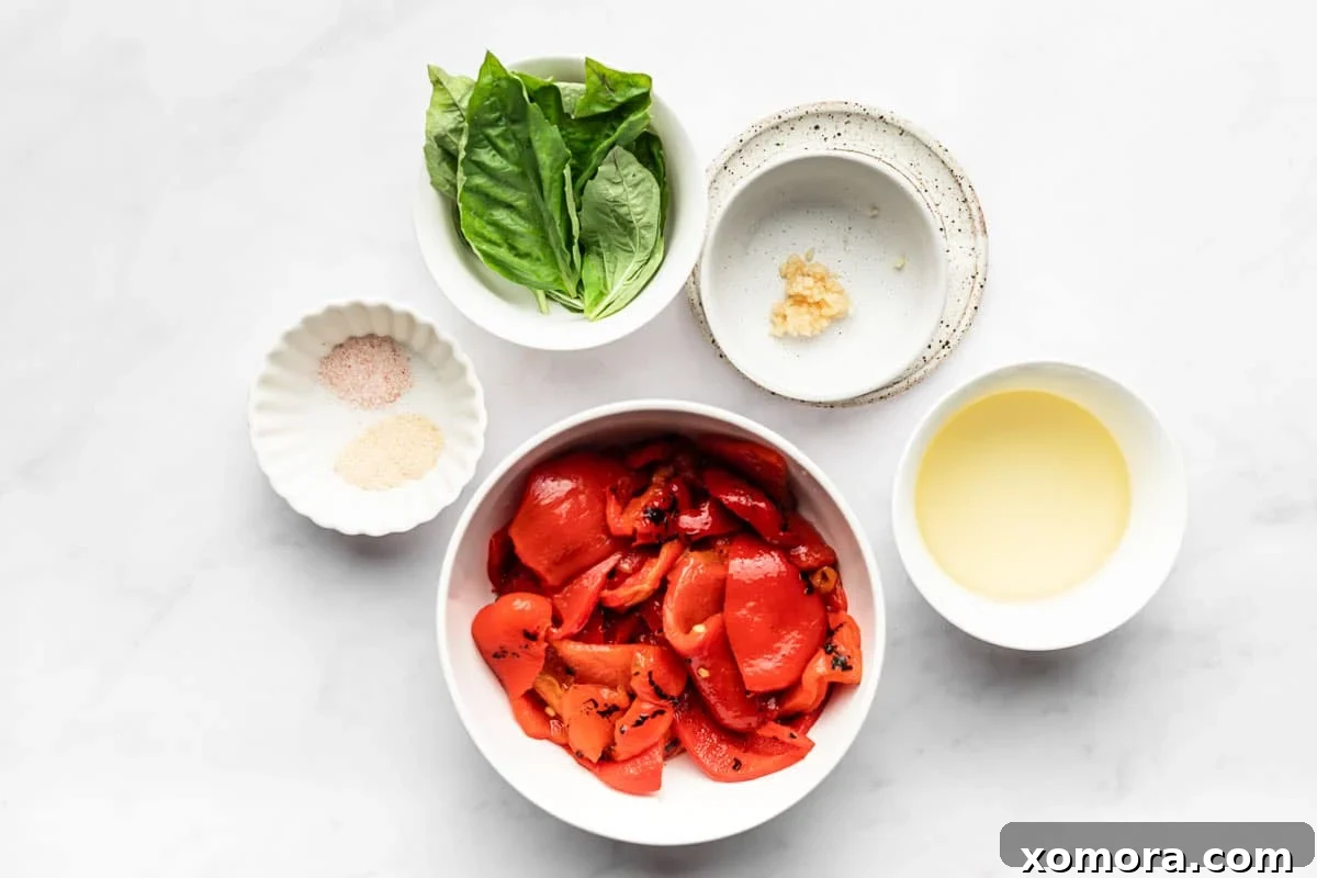 A top-down view of a creamy roasted red pepper sauce, with a spoon scooping a portion out of a bowl, indicating its luscious texture.