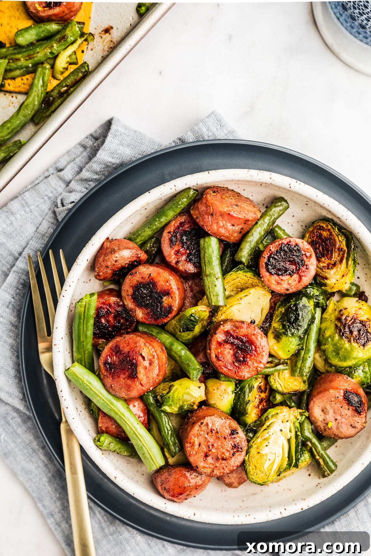 One-Pan Sausage and Roasted Vegetables 3 Close-up of roasted green beans and Brussels sprouts with visible charring.