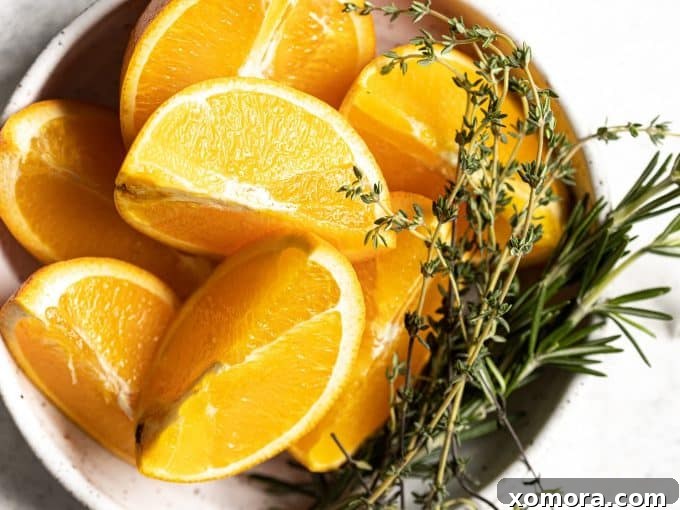 Citrus Herb Roasted Chicken with Crisp Potatoes 3 Fresh oranges, rosemary, and thyme on a wooden board