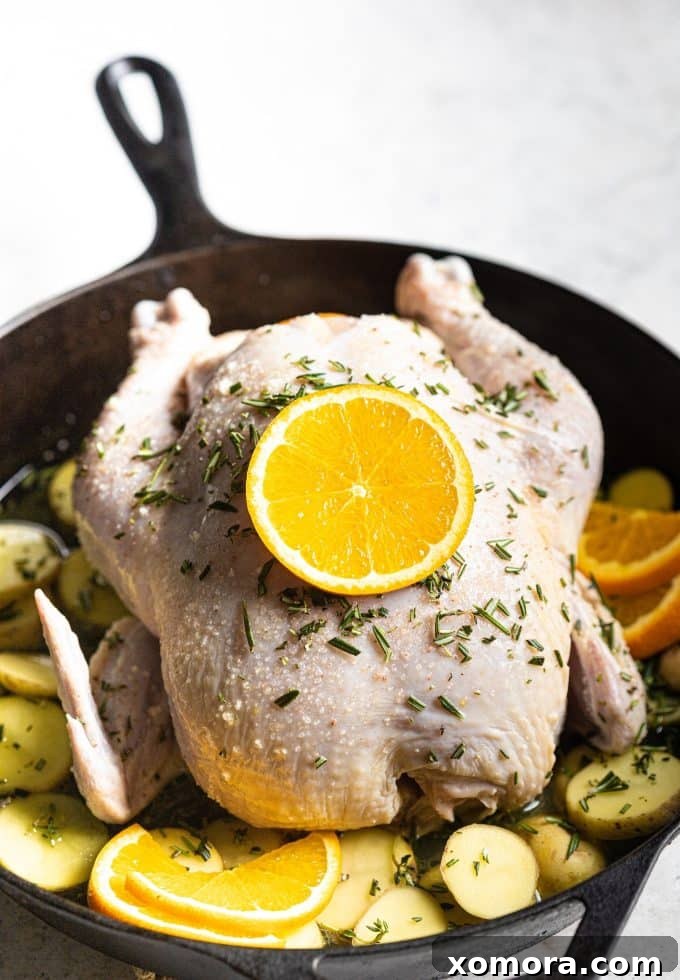 Citrus Herb Roasted Chicken with Crisp Potatoes 4 A whole roasted chicken with oranges and herbs in a cast iron skillet