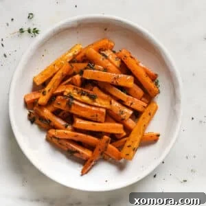 Close-up of freshly roasted carrots with lemon and thyme, ready for serving.
