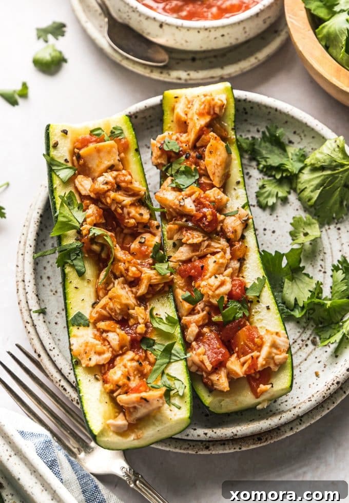 Fiesta Chicken Zucchini Boats 3 Close-up of a zucchini half being scooped out with a spoon to create a boat shape for filling.
