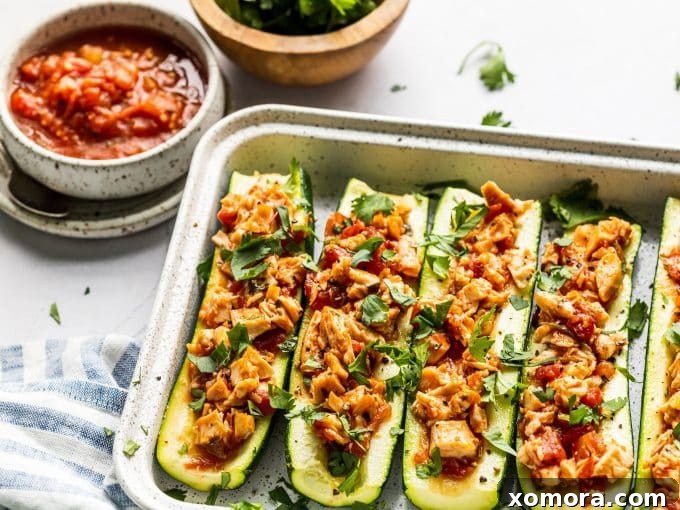 Fiesta Chicken Zucchini Boats 4 Ingredients for salsa chicken zucchini boats laid out: zucchini, olive oil, shredded chicken, salsa, and seasonings.