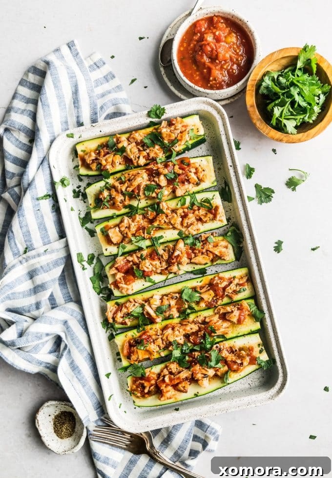 Fiesta Chicken Zucchini Boats 5 Baked salsa chicken zucchini boats garnished with fresh cilantro, ready to serve.