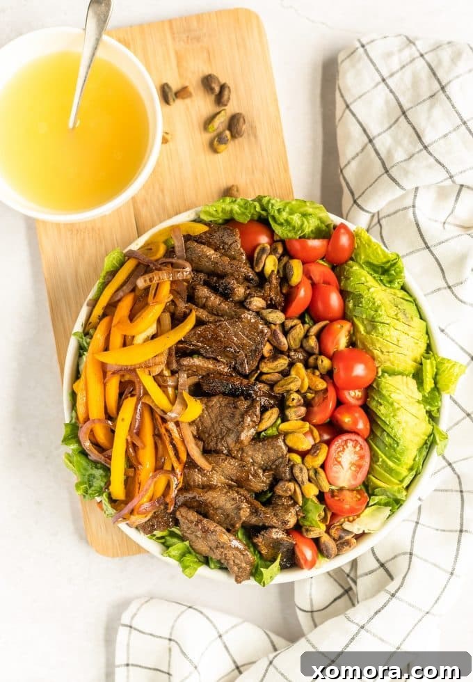 Fiesta Steak Salad with Citrus Vinaigrette 4 A close-up of the Southwestern Steak Salad being drizzled with the homemade lime vinaigrette, highlighting the fresh, glistening ingredients.