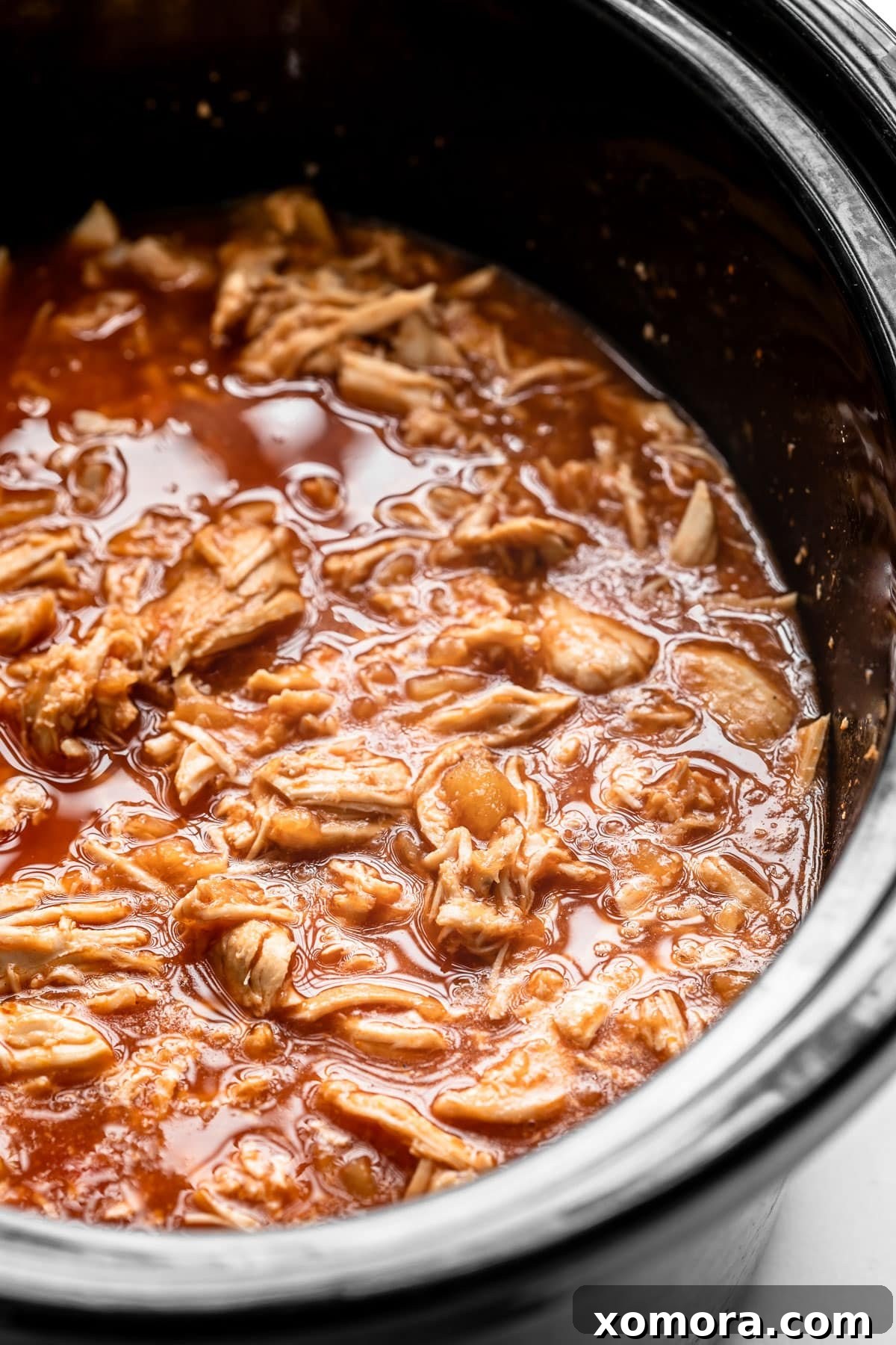 Slow Cooker Tropical Pulled Chicken 3 Slow Cooker Pineapple Chicken in the slow cooker, showing the chicken breasts simmering in the sauce.