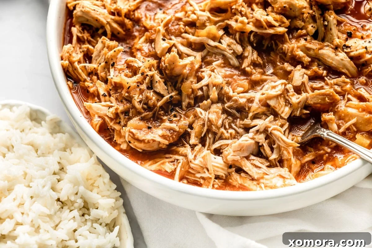Slow Cooker Tropical Pulled Chicken 5 A serving of Slow Cooker Pineapple Chicken presented with fresh herbs.