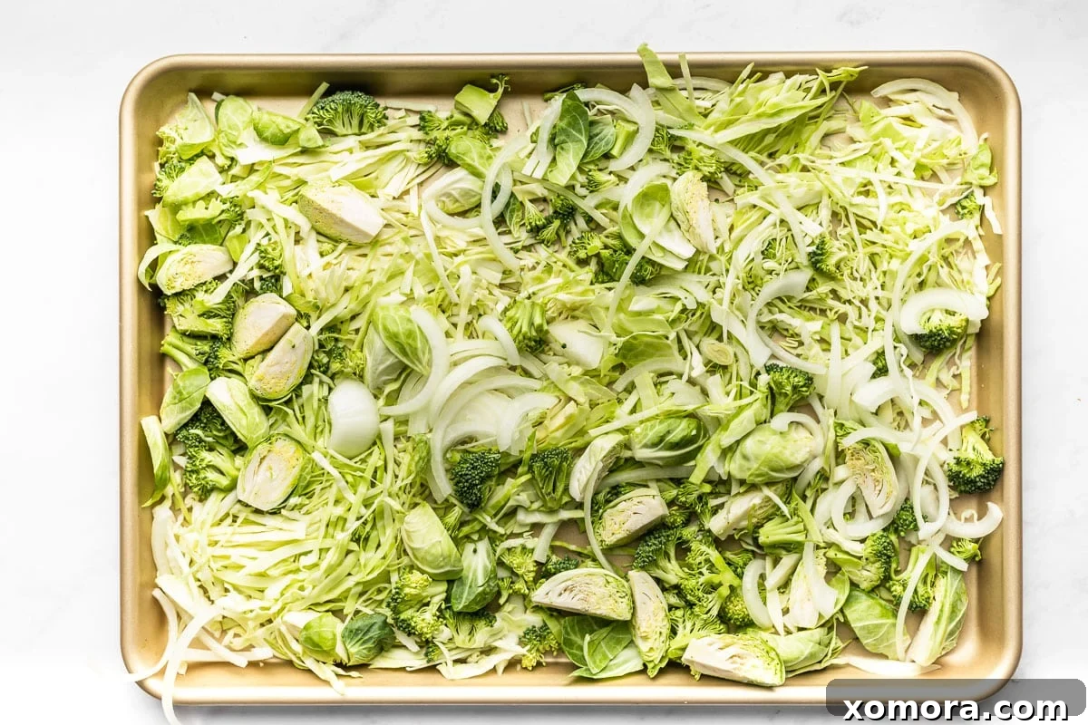 A close-up of the cooked sheet pan chicken and cabbage stir fry, showing the crispy texture of the roasted vegetables and juicy chicken.