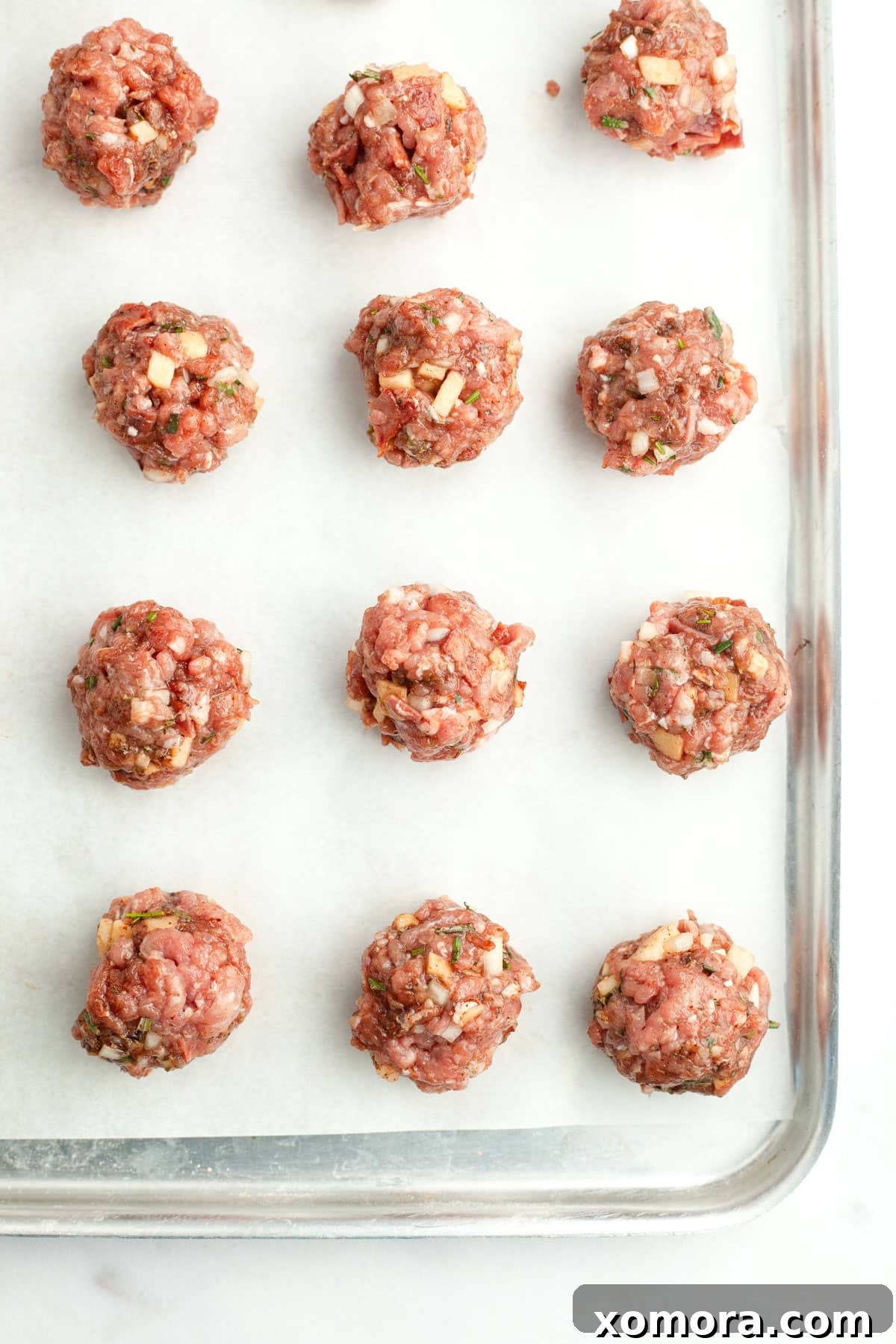 A close-up shot of a single baked turkey apple breakfast meatball, showing its texture and golden-brown exterior.