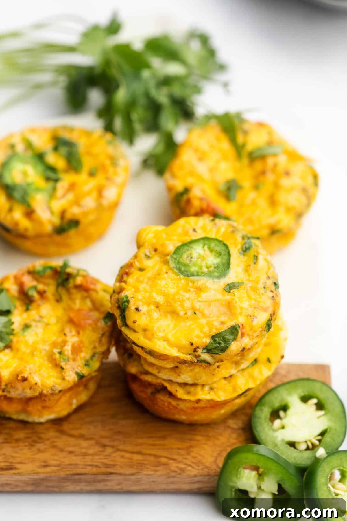 Salsa Chicken Egg Bites Low Carb Dairy Free 6 Several Salsa Chicken Egg Muffins stacked on a small wooden board