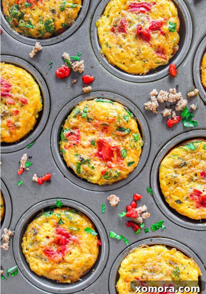 Savory Turkey Pizza Egg Cups 2 Close-up of baked Turkey Pizza Egg Muffins in a muffin tin, garnished with fresh herbs, showcasing their golden-brown tops and rich fillings.