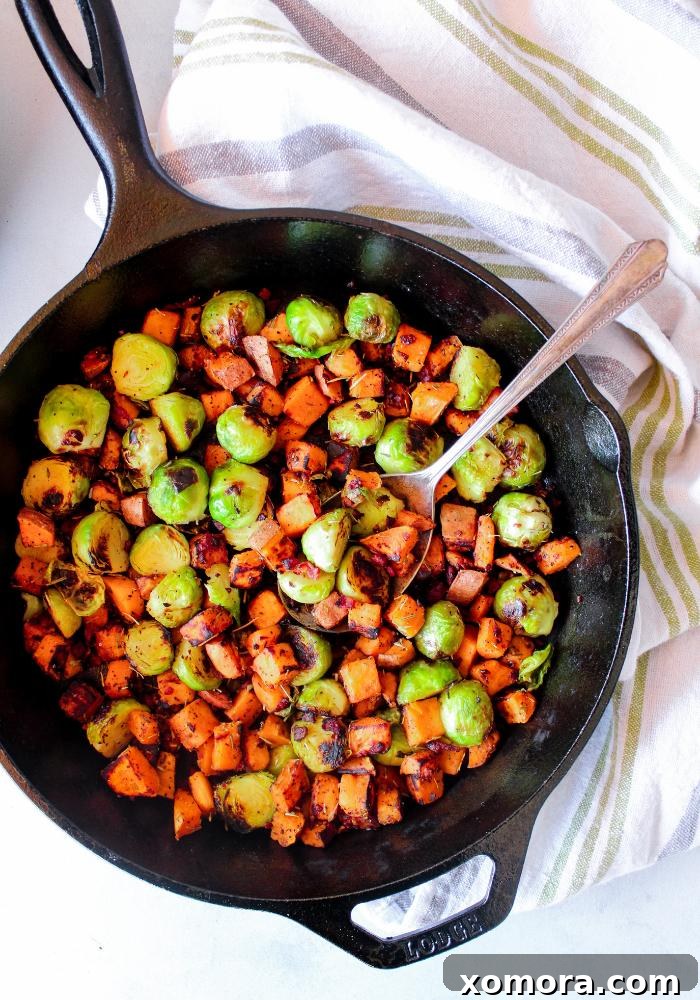 Smoky Bacon Sweet Potato Medley 2 A vibrant close-up of Sweet Potato Bacon Hash in a skillet, showcasing golden sweet potatoes, crispy bacon bits, and tender green Brussels sprouts.