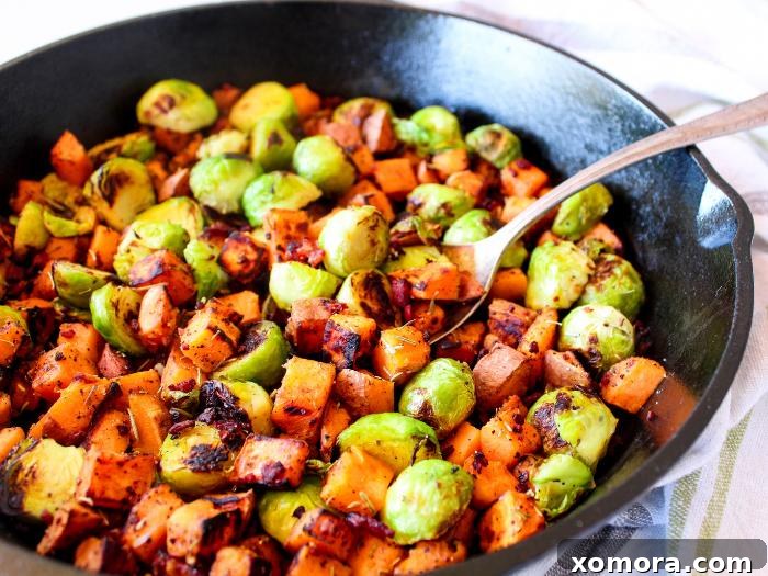 Smoky Bacon Sweet Potato Medley 3 A serving of Sweet Potato Bacon Hash on a plate, featuring perfectly cooked sweet potatoes, crispy bacon, and tender Brussels sprouts.