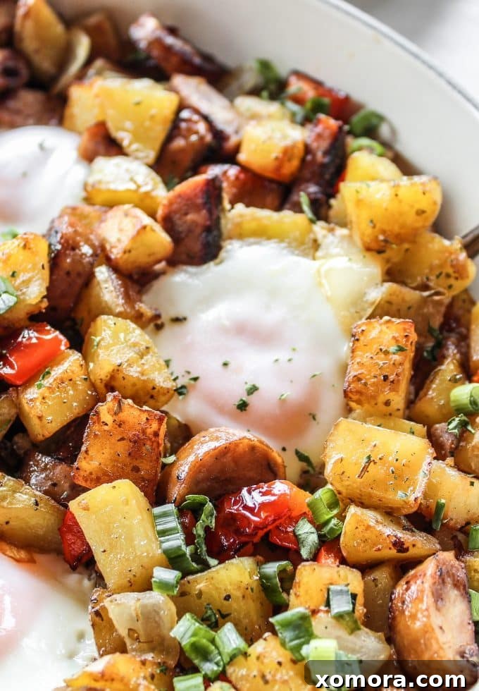 Rustic Chicken Sausage and Bell Pepper Hash 4 Four perfectly cooked eggs nestled in a skillet of chicken sausage and pepper hash, garnished with fresh herbs